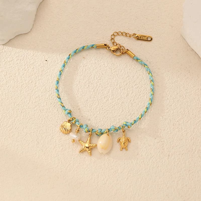 Pulsera con dijes de estrella de mar y concha sobre cadena de cordón