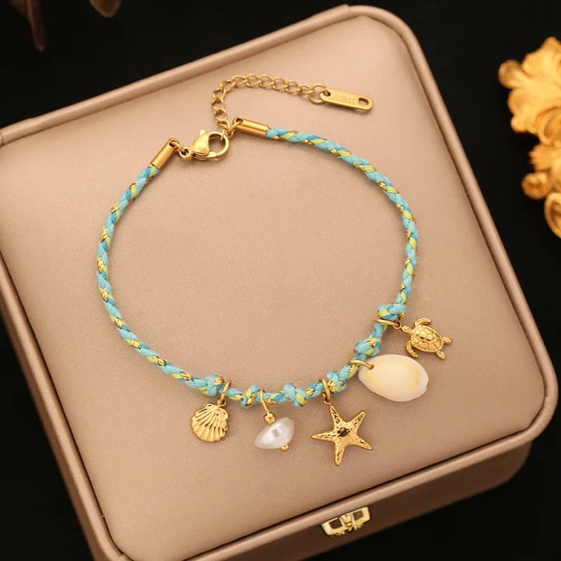 Pulsera con dijes de estrella de mar y concha sobre cadena de cordón