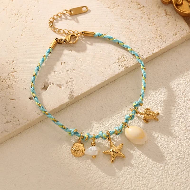 Pulsera con dijes de estrella de mar y concha sobre cadena de cordón
